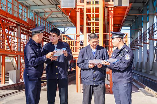 刑警支隊民警向企業(yè)職工發(fā)放宣傳資料并“一對一”講解電詐常識。謝仁古力·托呼提 攝